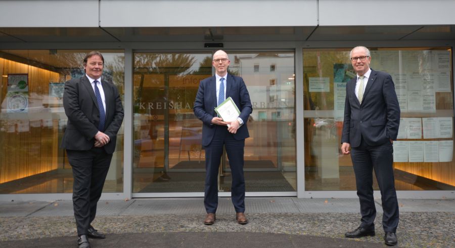 Der Kreis Paderborn und die Stadt Bielefeld haben in den vergangenen Wochen „fair und auf Augenhöhe“ verhandelt. Im Paderborner Kreishaus konnte jetzt der Vertrag abgeschlossen werden. Rainer Kaschel, Notar Johannes Auffenberg und Landrat Manfred Müller vor dem Paderborner Kreishaus  Bildnachweis: Amt für Presse- und Öffentlichkeitsarbeit, Kreis Paderborn, Ulrike Sander